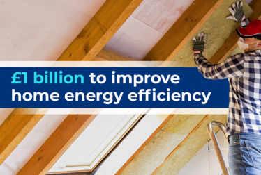 £1 Billion to improve home energy efficiency. A builder installing roof insulation.